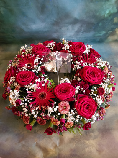 Red wreath - Round wreath of mixed red flowers to include red roses and lush green foliage.