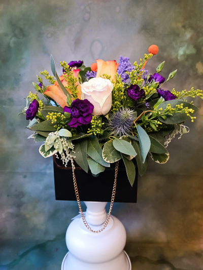 Cute Handbag flower arrangement - Unique flower arrangements in handbags available in Pink, Black and White colours. Composed of minimum of 3 roses (multiple colours available) and selection of seasonal flowers.