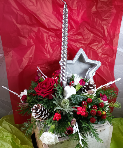 Christmas time - A table arrangement with a candle in a star-shaped ceramic pot .