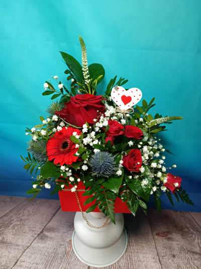 Colors of love - A composition of red flowers in a charming imitation of a woman's handbag.